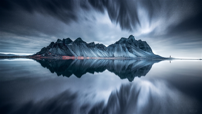 Mountain reflected in water with person