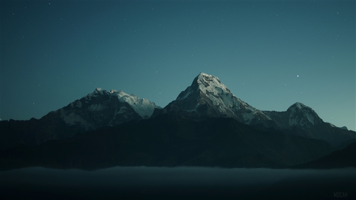 Snow-capped mountains under a starry night sky