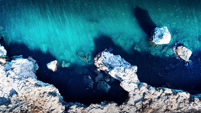 Aerial Drone View of Rocky Coastline and Turquoise Water 4K