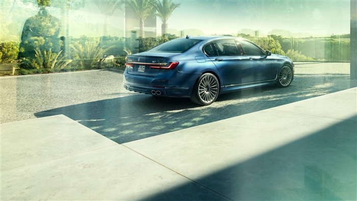 Blue Alpina B7 parked near a modern building