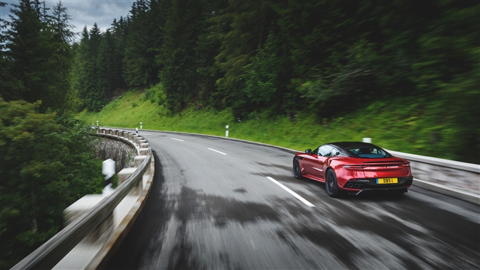 Red Aston Martin DBS Superleggera driving on a mountain road