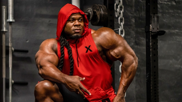 Kai Greene in a red hoodie in a gym