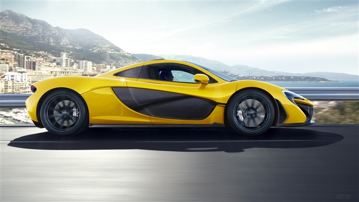 Yellow McLaren P1 driving on a coastal road