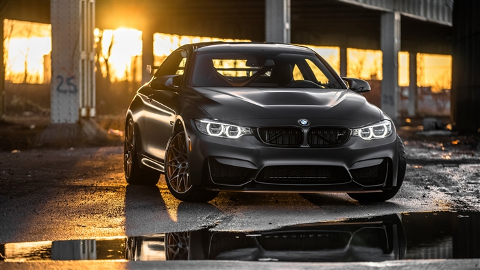 Matte black BMW M4 GTS parked outdoors at sunset