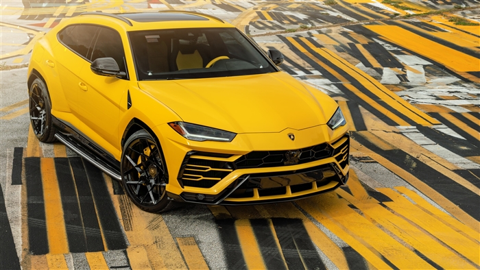 Yellow Lamborghini Urus on striped pavement