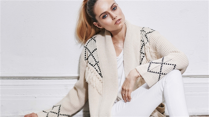 Anine Bing woman in cream cardigan and white jeans