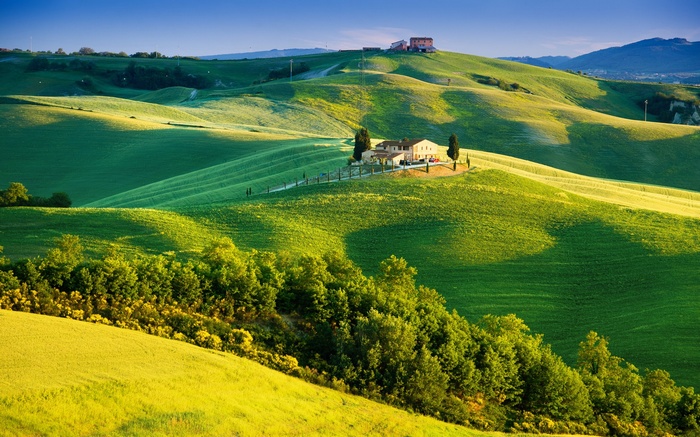 Tuscan landscape with rolling green hills and a farmhouse