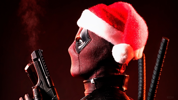 Deadpool wearing a Santa hat with a gun
