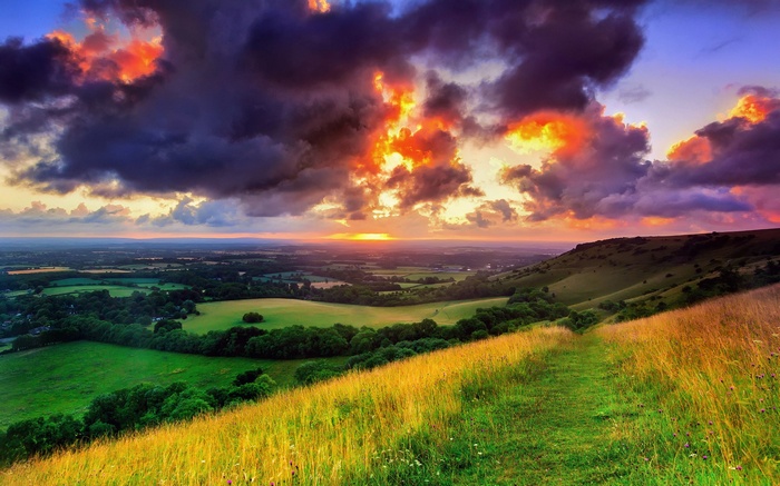 Dramatic sunset over rolling green hills and fields