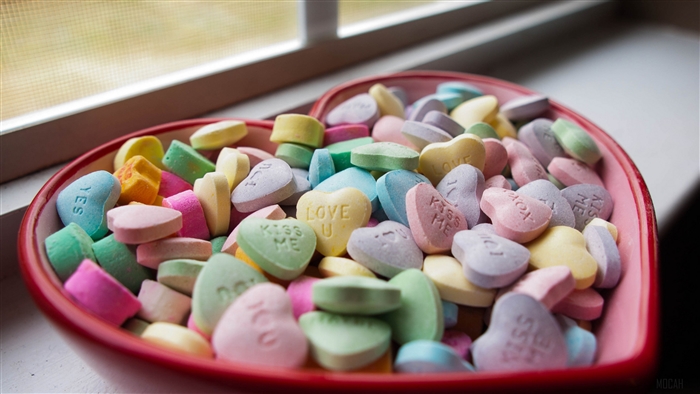 Heart-shaped bowl of Valentine's Day candy hearts