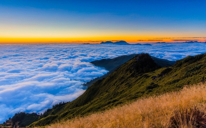 Mountain peaks above a sea of clouds at sunrise