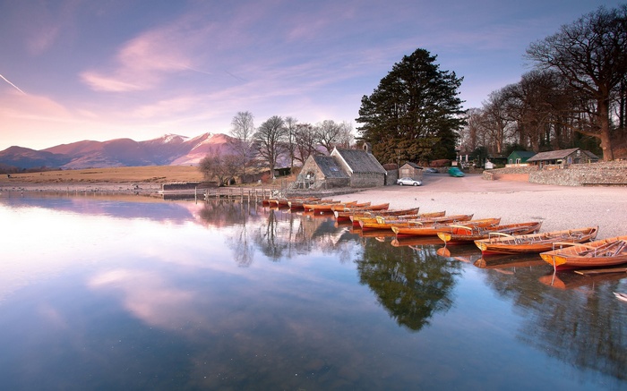 Boats on a lake with mountains in the background