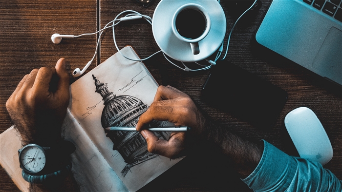 Artist sketching a dome building with headphones and coffee