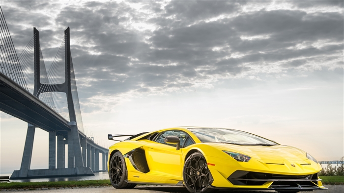 Yellow Lamborghini Aventador SVJ near Vasco da Gama Bridge