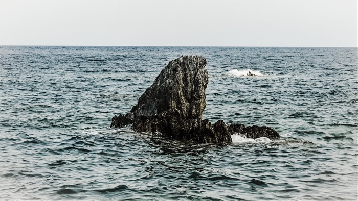 Rock formation in the sea under a pale sky