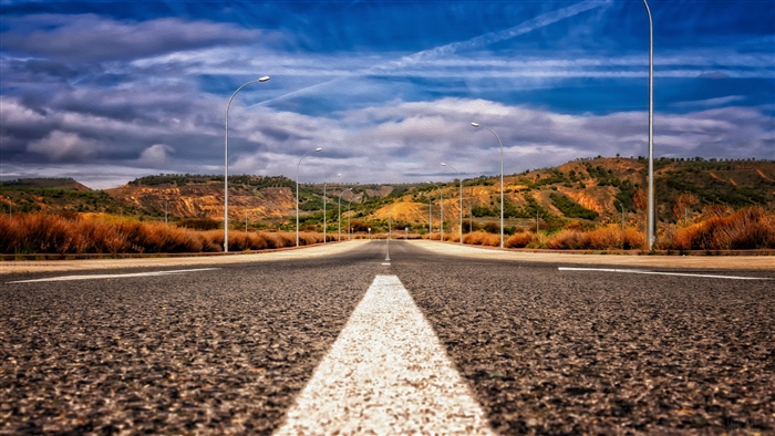 Asphalt road with white marking and mountains