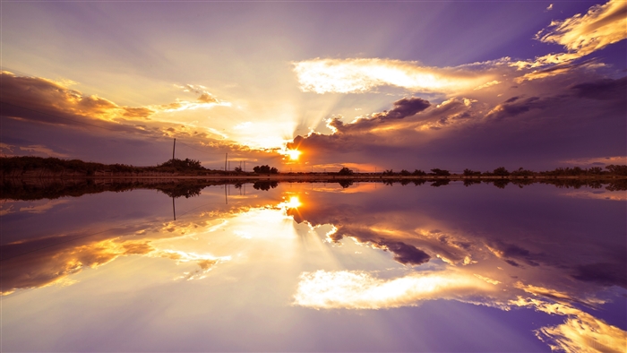 Sunset over lake with dramatic clouds and reflection