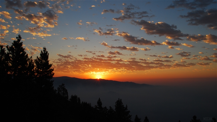 Sunset over mountains with clouds and trees 4K