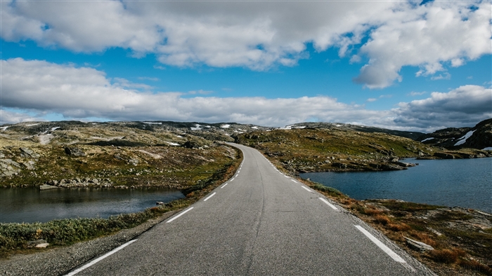 Road with markings in a mountainous landscape with lakes