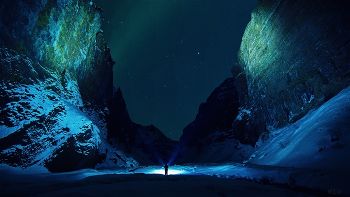 Man with flashlight in snowy mountains under starry sky 4K