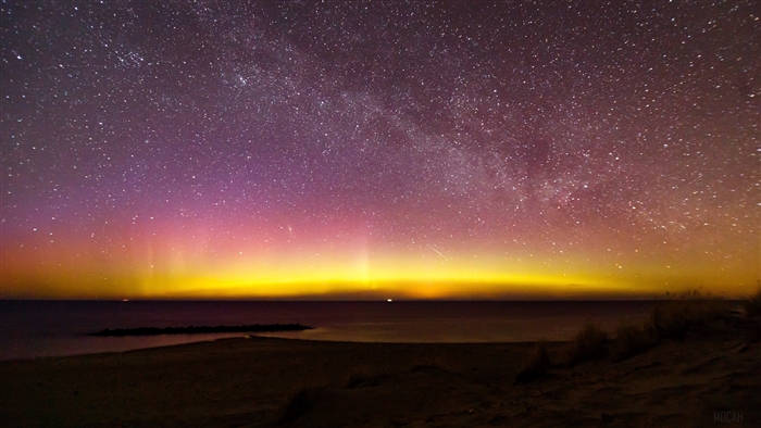 Aurora Borealis over the sea and starry sky