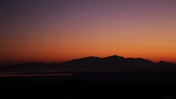 Mountains and city lights at sunset 4K