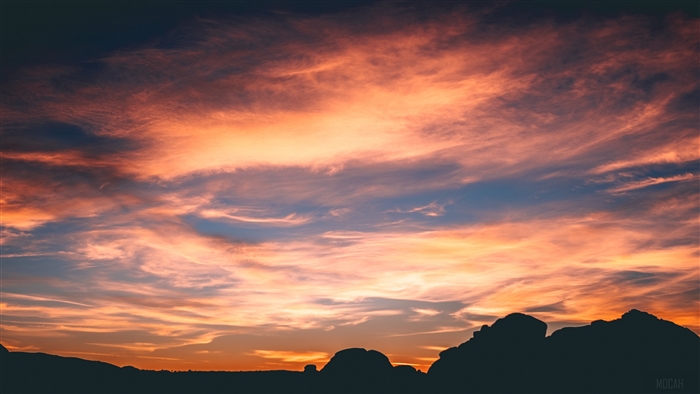 Silhouette of rocks against a dramatic sunset sky with clouds 4K