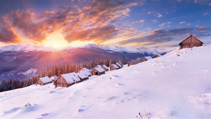 Wooden houses on a snowy mountain slope at sunset 4K