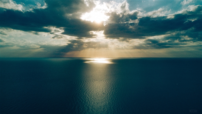 Sunlight breaking through clouds over the sea