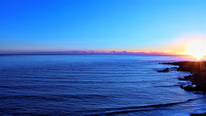 Ocean and rocky coastline at sunset 4K