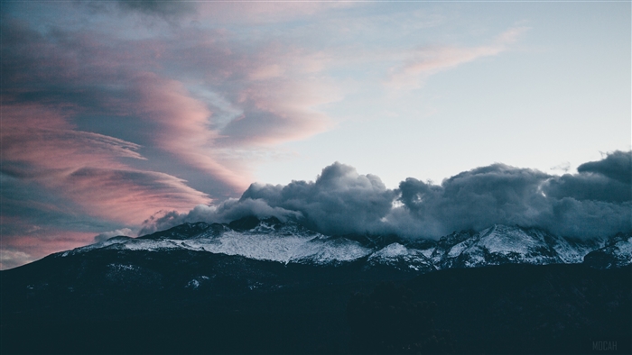 Snow-capped mountains under pink and grey clouds