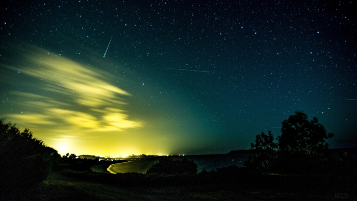 Starry night sky with aurora and clouds