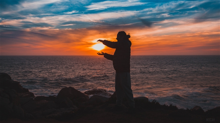 Man holding the sun at sunset over the sea 4K