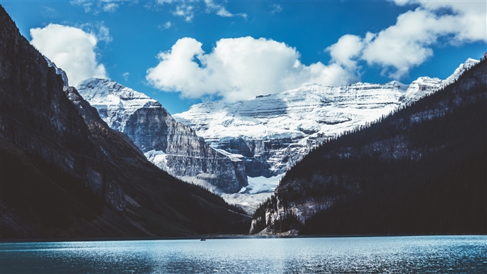 Snow-capped mountains over a lake with clouds 4K