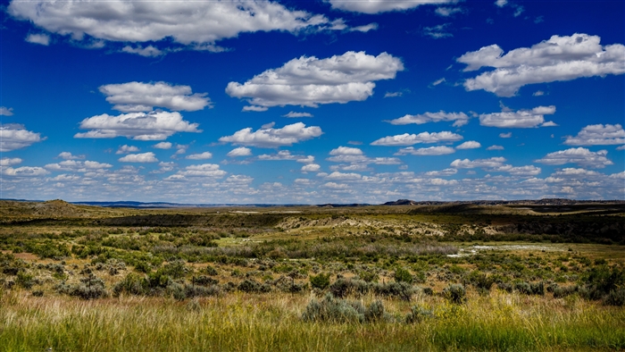 Vast landscape with rolling hills and scattered clouds