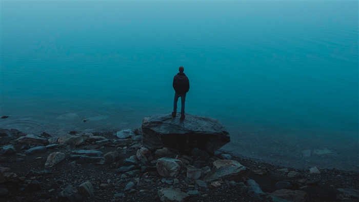 Man standing on a rock by the sea 4K