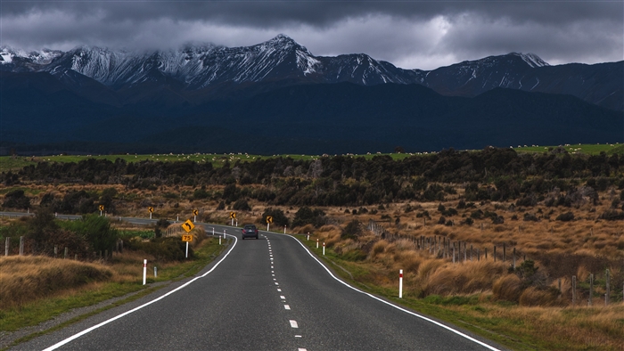 Road leading to snow-capped mountains in New Zealand 4K