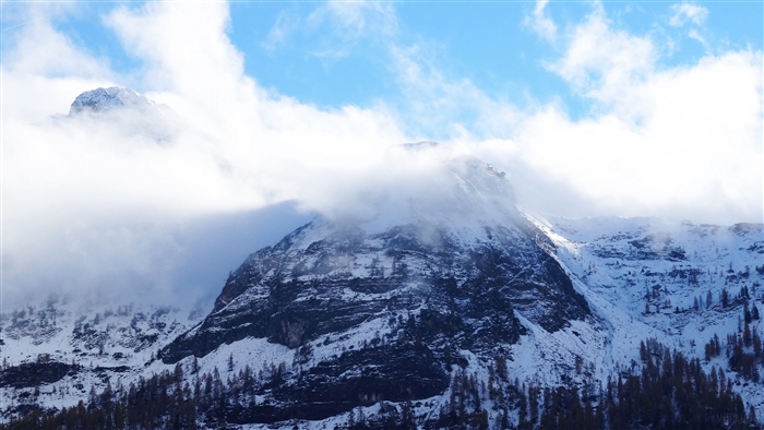 Snowy Mountain Peak with Fog and Blue Sky 4K