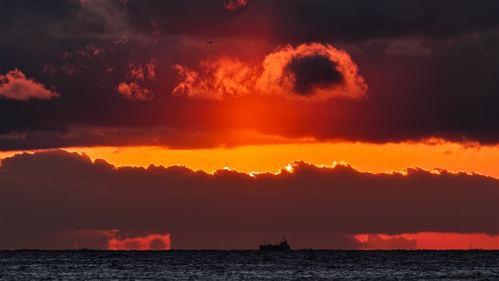 Sunset over the sea with clouds and ship 4K