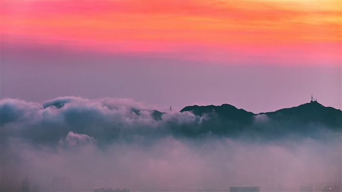 Mountain peaks shrouded in fog at sunrise