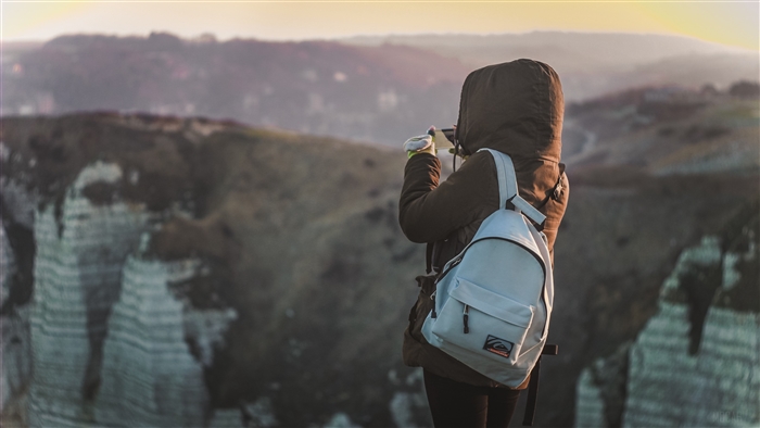 Person with backpack taking photo in mountains 4K