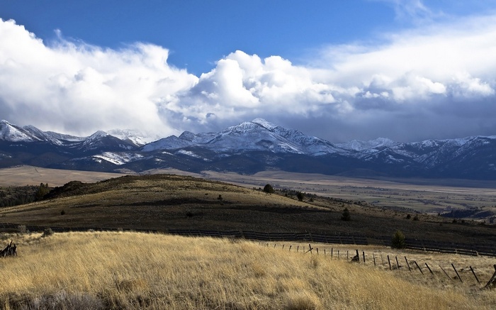 Snow-capped mountains under a cloudy sky