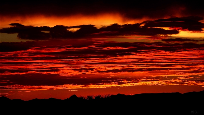 Fiery sunset over silhouetted mountains