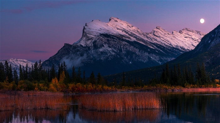 Mountains and lake at twilight with moon