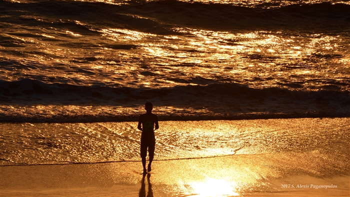 Silhouette of a person running on a beach at sunset