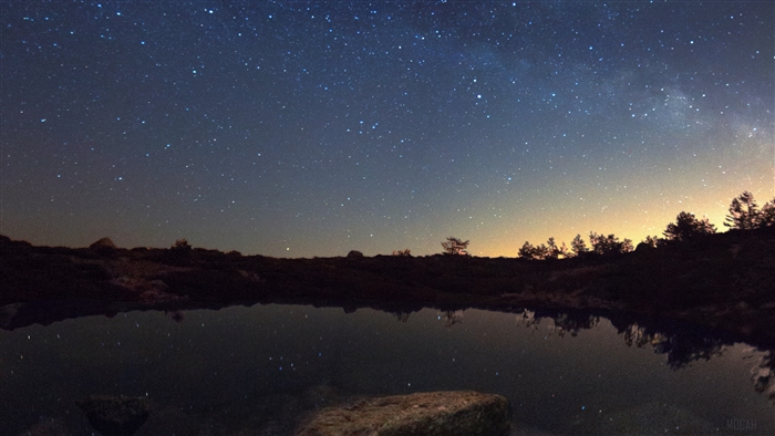 Starry night sky reflected in a lake