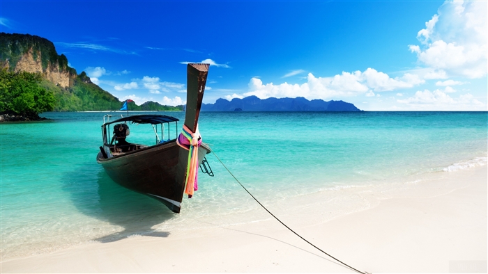 Boat moored on a tropical beach with turquoise water