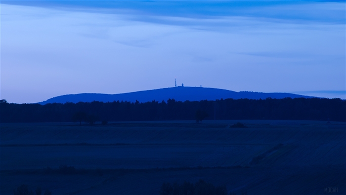 Blue evening landscape with distant mountain and radio towers