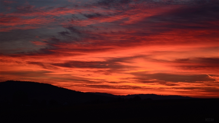 Dramatic red sunset over dark hills 4K