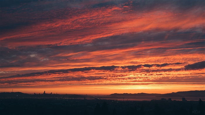 Sunset over city skyline with dramatic clouds